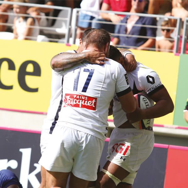 Joueurs de l'ASM Clermont célébrant un but pendant un match.