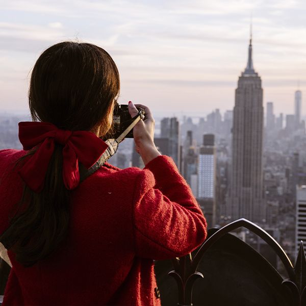 A woman taking a picture of the view on NY city.